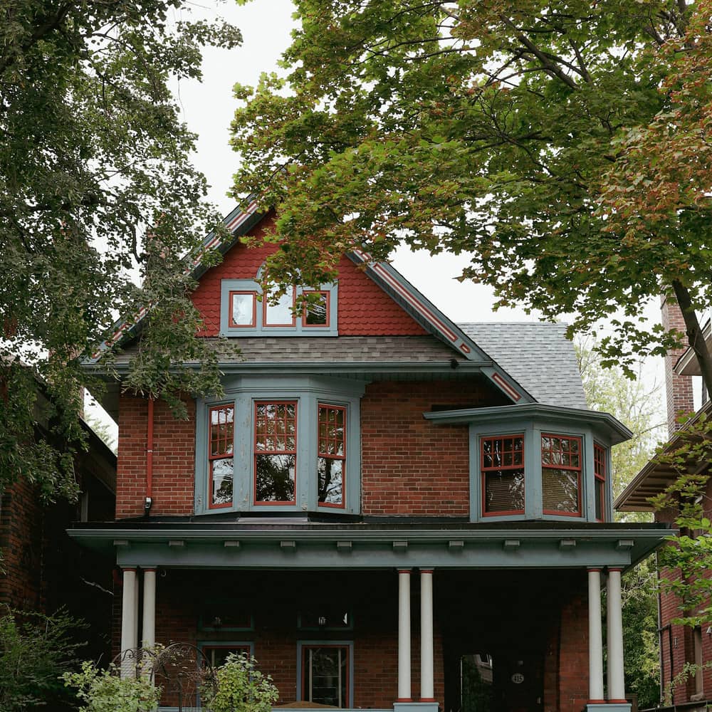 A red-brick Toronto home with a deep front porch